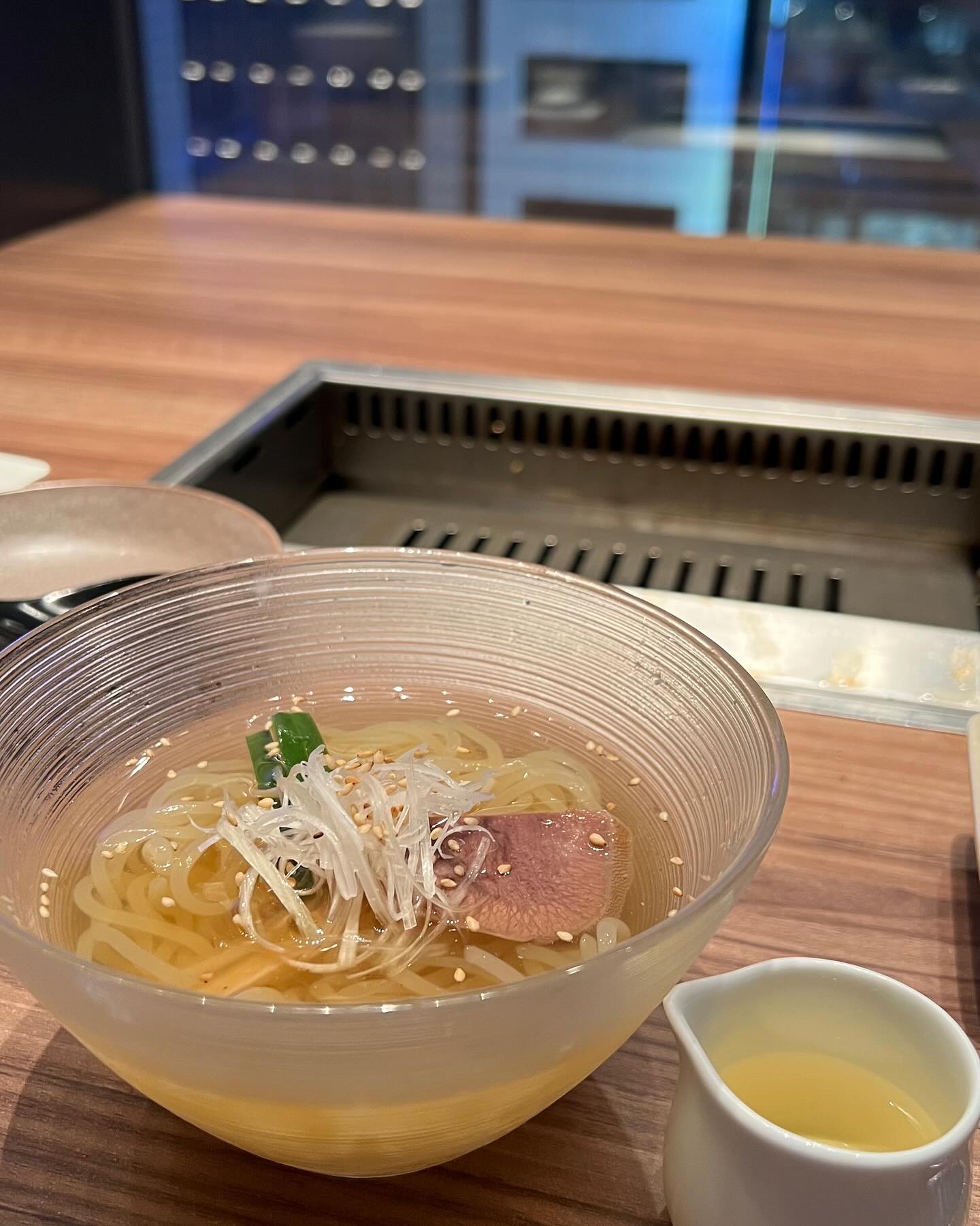 ねぎを添えた麺の皿と卓上ロースター